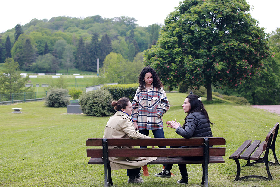 Trois femmes discutent sur un banc dans un parc verdoyant à Jouy-en-Josas.