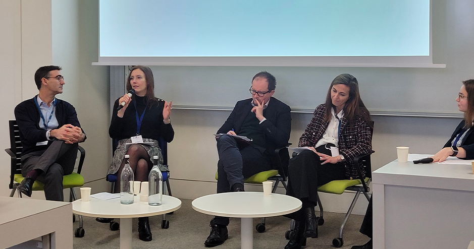 HEC Paris and HKUST Pioneer Sustainable Finance Research Across Continents. A panel discussion featuring experts in sustainable finance at HEC Paris. A female speaker is addressing the audience with a microphone, while panelists, including academics and industry professionals, engage in discussion. The event highlights cross-continental collaboration in advancing sustainable finance research