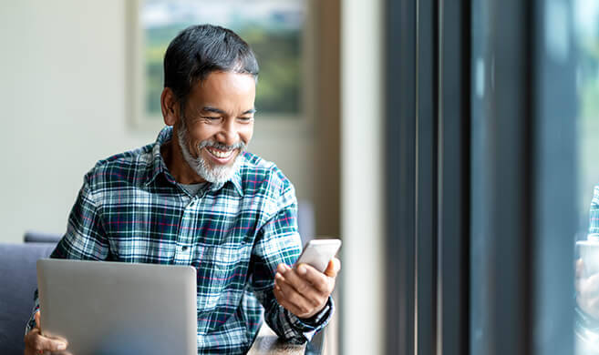 old man laughing while seeing his phone