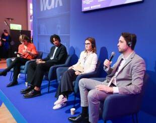 Professor Leandro Nardi speaks at the Women's Forum, surrounded by other participants.